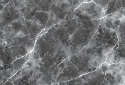 The primary subject of the image is a marble surface with a pattern of veins and cracks. The setting is a dark room, and the visual style is a close-up of the marble surface. The colors and mood of the image are dark and moody, with the marble surface being the main focus.