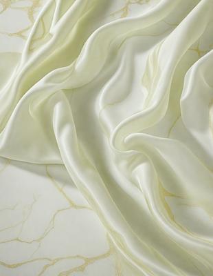The primary subject of the image is a white sheet of fabric, which is the main object in the scene. The setting is a white background, and the visual style appears to be a photo. The colors in the image are predominantly white, giving it a clean and minimalist appearance. The overall mood of the image is calm and serene.