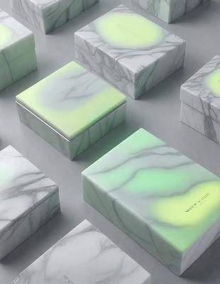 The primary subject of the image is a collection of square boxes with a marbled pattern. The setting is a white background, and the visual style is a photo. The dominant colors are green and white, creating a calm and soothing atmosphere.