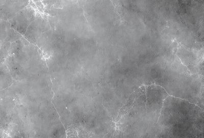The primary subject of the image is a gray wall with a pattern of white lines. The setting is a room with a gray background. The visual style is a close-up of the wall, showcasing the intricate pattern of the white lines. The colors and mood of the image are predominantly gray, creating a calm and minimalistic atmosphere.