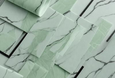 The primary subject of the image is a marble-like pattern, which is a combination of green and white colors. The setting is a wall with a marble-like pattern, and the visual style is a close-up of the pattern. The colors and mood of the image are predominantly green and white, creating a clean and elegant atmosphere.