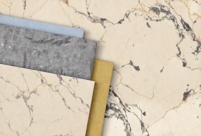 The primary subject of the image is a collection of different colored papers, including yellow, blue, and gray, arranged on a marble surface. The setting is a marble countertop, and the visual style appears to be a photo. The colors and mood of the image are predominantly neutral, with the marble surface adding a touch of elegance and sophistication.