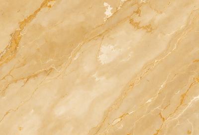 The primary subject of the image is a marble wall with a yellowish hue. The setting is a room with a marble floor, and the visual style is a close-up of the marble wall. The colors and mood of the image are warm and inviting, with the marble wall and floor creating a luxurious and elegant atmosphere.