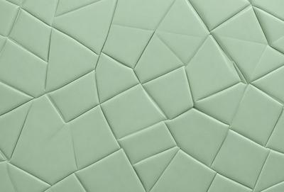 The primary subject of the image is a green tile wall with a pattern of triangles. The setting is a room with a green tile wall, and the visual style is a close-up of the tile pattern. The dominant colors are green and white, creating a calm and soothing atmosphere.