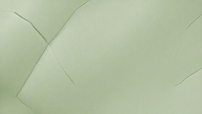 The primary subject of the image is a piece of green paper. The setting is a white background, and the visual style appears to be a photo. The colors and mood of the image are predominantly green, giving it a calm and serene atmosphere.