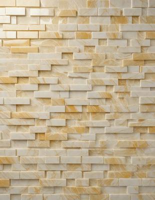 The primary subject of the image is a wall made of marble tiles. The setting is a room with a marble wall, and the visual style is a close-up of the marble tiles. The colors and mood of the image are predominantly yellow, giving it a warm and inviting atmosphere.