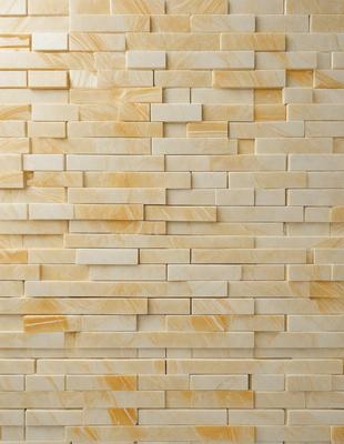 The primary subject of the image is a large, white brick wall. The setting is a room with a brick wall, and the visual style is a photo. The dominant colors are white and yellow, creating a warm and inviting atmosphere.