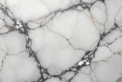 The primary subject of the image is a marble countertop with a white and gold color scheme. The setting is a kitchen, and the visual style is a close-up of the marble countertop. The colors and mood of the image are elegant and sophisticated, with the white marble providing a clean and refined appearance, while the gold accents add a touch of luxury and warmth to the overall design.