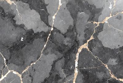 The primary subject of the image is a marble countertop with a black and gold pattern. The setting is a kitchen, and the visual style is a close-up of the countertop. The dominant colors are black and gold, creating a luxurious and elegant atmosphere.