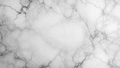 The primary subject of the image is a marble countertop with a white marble finish. The setting is a kitchen or bathroom environment, with the countertop being the main focus. The visual style is a photo, capturing the natural texture and beauty of the marble surface. The colors and mood of the image are predominantly white, giving it a clean and elegant appearance.