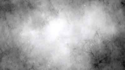 The primary subject of the image is a white, cloudy sky. The setting is a gray, textured background, which adds to the overall atmosphere. The visual style is a black and white photo, giving it a classic and timeless appearance. The colors and mood convey a sense of calmness and tranquility, as the sky is the main focus of the image.