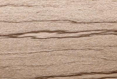The primary subject of the image is a wooden surface, possibly a table or a wall, with a pattern of wood grain visible. The setting is a room with a wooden floor, and the visual style appears to be a close-up of the wooden surface. The colors and mood of the image are predominantly brown, giving it a warm and natural atmosphere.
