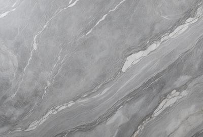 The primary subject of the image is a marble wall with a patterned texture. The setting is a room with a grey marble wall as the main focus. The visual style is a close-up of the marble wall, showcasing its intricate pattern. The colors and mood of the image are predominantly grey, giving it a sophisticated and elegant appearance.