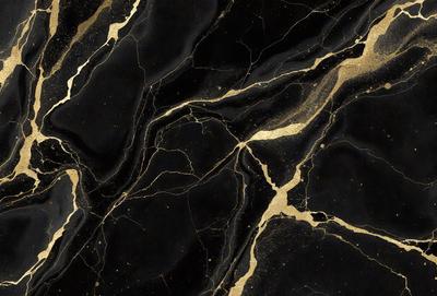 The primary subject of the image is a close-up of a marble surface with gold accents. The setting is a black and gold marble wall, which serves as the background. The visual style is a combination of a photo and digital art, creating a unique and intricate pattern. The colors and mood of the image are predominantly black and gold, giving it a luxurious and elegant appearance.