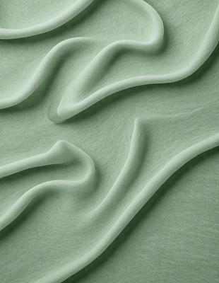 The primary subject of the image is a green, wavy surface that resembles a piece of fabric or a sculpture. The setting is a close-up view of the surface, which appears to be a textured material. The visual style is a combination of a photo and a digital art, illustration, or drawing. The colors are predominantly green, and the overall atmosphere is smooth and flowing.