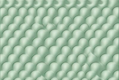 The primary subject of the image is a green, textured surface with a pattern of round, white bubbles. The setting appears to be a room with a green wall, and the visual style is a close-up of the textured surface. The colors and mood of the image are predominantly green and white, creating a calm and soothing atmosphere.