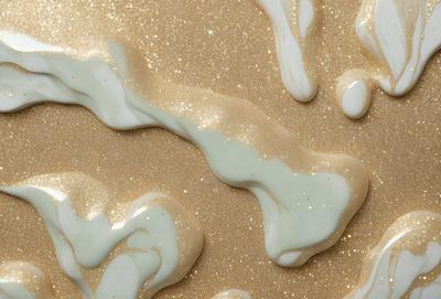 The primary subject of the image is a close-up of a white and gold substance, possibly a cream or a frosting, with a sandy texture. The setting is a sandy surface, and the visual style appears to be a combination of a photo and digital art. The colors and mood of the image are predominantly white and gold, giving it a warm and inviting atmosphere.