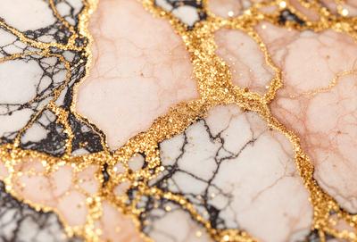 The primary subject of the image is a marble surface with gold glitter on it. The setting is a marble countertop, and the visual style is a close-up of the marble with gold glitter. The colors and mood of the image are predominantly gold and glittery, creating a luxurious and elegant atmosphere.
