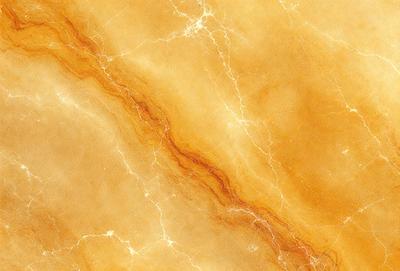 The primary subject of the image is a marble surface with a yellowish hue. The setting is a room with a yellow marble wall, and the visual style is a close-up of the marble surface. The colors and mood of the image are warm and inviting, with the yellow marble creating a sense of warmth and natural beauty.