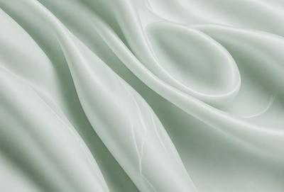The primary subject of the image is a white sheet of fabric, which is the main object, scene, or focus of the image. The setting or background is a white sheet of fabric, and the visual style is a photo. The colors and mood of the image are predominantly white, giving it a clean and minimalist appearance.