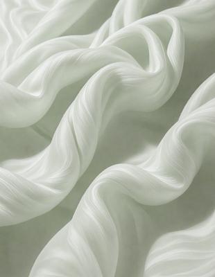 The primary subject of the image is a white, flowing, and curly fabric. The setting is a white background, which creates a clean and minimalistic appearance. The visual style is a close-up of the fabric, showcasing its texture and details. The colors and mood of the image are predominantly white, giving it a serene and calming atmosphere.