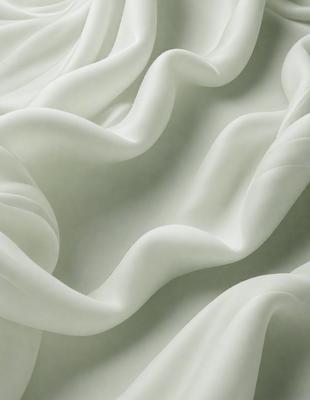 The primary subject of the image is a white sheet of fabric, which is the main object, scene, or focus of the image. The setting or background consists of a white wall, and the visual style appears to be a photo. The colors and mood of the image are predominantly white, giving it a clean and minimalist appearance.