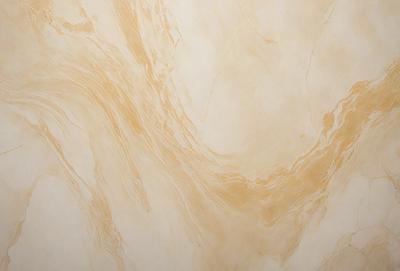 The primary subject of the image is a marble wall with a gold-colored pattern. The setting is a room with a white background. The visual style is a close-up of the marble wall, showcasing its intricate design. The colors and mood of the image are warm and elegant, with the gold pattern and white background creating a luxurious and sophisticated atmosphere.