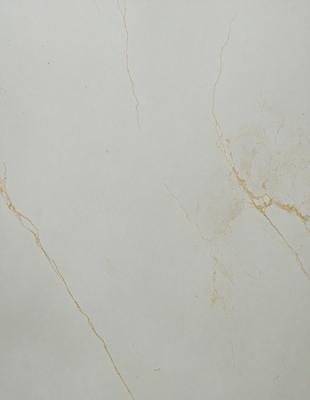 The primary subject of the image is a white marble wall with a yellowish tint. The setting is a room with a white background. The visual style is a close-up of the marble wall, showcasing its texture and color. The colors and mood of the image are predominantly white and yellow, giving it a warm and natural ambiance.