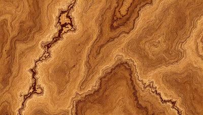 The primary subject of the image is a wooden surface with a unique and intricate pattern. The setting is a close-up view of the wooden surface, showcasing its texture and details. The visual style is a close-up of the wooden surface, which gives a sense of depth and complexity to the pattern. The colors and mood of the image are warm and earthy, with the wooden surface being the main focus of the image.