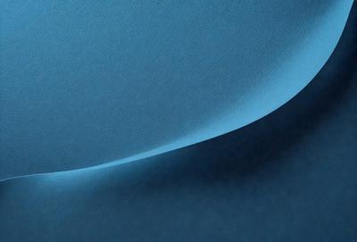 The primary subject of the image is a blue surface, which appears to be a piece of leather or a similar material. The setting is a dark room, and the visual style is a close-up of the blue surface. The colors and mood of the image are predominantly dark and moody, with the blue surface being the main focal point.