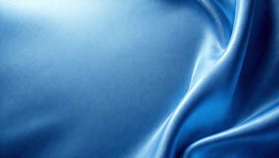 The primary subject of the image is a blue fabric, which appears to be a piece of leather. The setting is a close-up view of the fabric, showcasing its texture and color. The visual style is a realistic representation of the fabric, with no indication of it being a photo, digital art, illustration, drawing, pattern, texture, or clipart. The dominant colors are blue and silver, creating a calm and soothing atmosphere.