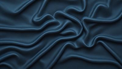 The primary subject of the image is a blue fabric with a wavy pattern. The setting is a close-up of the fabric, showcasing its texture and design. The visual style is a detailed, up-close view of the fabric. The colors and mood of the image are predominantly blue, creating a calm and soothing atmosphere.