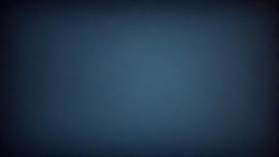 The primary subject of the image is a blue sky with no clouds. The setting is a dark blue background, which creates a contrast with the bright blue sky. The visual style is a simple, clean, and minimalistic representation of the sky. The colors and mood of the image are predominantly dark and moody, with the blue sky providing a sense of calmness and tranquility.