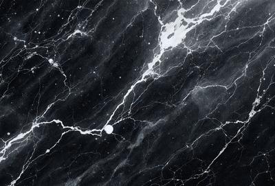 The primary subject of the image is a marble surface with a black and white color scheme. The setting is a black and white photograph of the marble surface, which appears to be a wall or a countertop. The visual style is a black and white photograph, giving the image a classic and timeless appearance. The colors and mood of the image are predominantly black and white, creating a sense of elegance and sophistication.