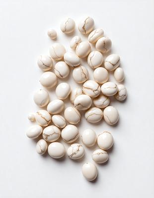 The primary subject of the image is a collection of white eggs. The setting is a white background, which provides a clean and uncluttered appearance. The visual style is a close-up of the eggs, showcasing their details and texture. The colors and mood of the image are predominantly white, giving it a clean and fresh appearance.