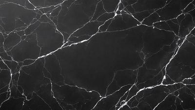 The image features a black marble countertop with a pattern of white veins. The countertop appears to be a part of a kitchen or bathroom setting. The overall atmosphere of the image is dark and moody, with the black marble countertop contrasting against the white veins.