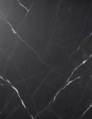 The primary subject of the image is a black marble countertop. The setting is a kitchen, with the countertop being the main focus of the scene. The visual style is a close-up of the marble countertop, showcasing its texture and pattern. The colors and mood of the image are predominantly dark, with the black marble countertop being the main source of contrast.