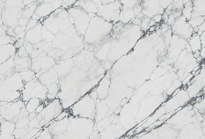 The image features a white marble wall with a pattern of holes and grooves. The wall appears to be a part of a building, possibly a bathroom or a kitchen. The marble wall has a unique texture and pattern, giving it a distinctive and elegant appearance.