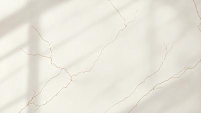 The primary subject of the image is a white wall with a crack in it. The setting is a room with a white wall, and the visual style is a photo. The crack in the wall adds a sense of imperfection to the otherwise clean and pristine appearance of the room.