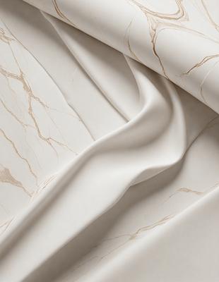 The primary subject of the image is a white marble-like material, which appears to be a fabric or a wallpaper with a marble pattern. The setting is a room with a marble-like wallpaper or fabric, and the visual style is a close-up of the material. The colors and mood of the image are predominantly white, giving it a clean and elegant appearance.