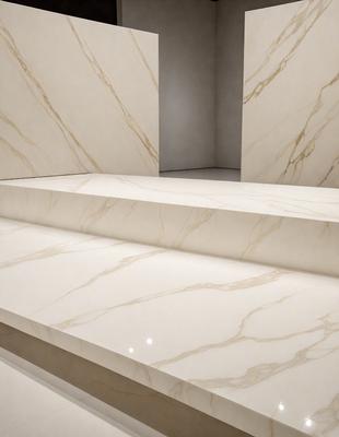 The image features a marble staircase with a white marble surface. The stairs are made of marble and have a step-like structure. The setting is a room with a white marble wall, which adds to the overall aesthetic of the space. The visual style of the image is a close-up of the marble staircase, showcasing the intricate details of the marble surface. The colors and mood of the image are predominantly white, giving it a clean and elegant appearance