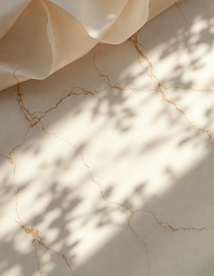 The primary subject of the image is a marble countertop with a gold-colored surface. The setting is a room with a window, and the visual style is a photo. The countertop has a pattern of leaves, and the colors and mood are warm and inviting.