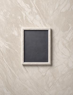 The primary subject of the image is a black and white picture frame. The setting is a marble wall, and the visual style is a photo. The colors and mood of the image are predominantly black and white, giving it a classic and timeless appearance.