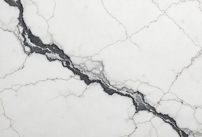 The primary subject of the image is a marble wall with a crack in it. The setting is a white marble surface, and the visual style is a close-up of the cracked marble. The colors and mood of the image are predominantly white, giving it a clean and minimalist appearance.