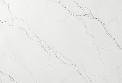 The primary subject of the image is a white marble wall with a pattern of cracks and holes. The setting is a room with a white marble floor. The visual style is a close-up of the marble wall, showcasing its unique texture and pattern. The colors and mood of the image are predominantly white, giving it a clean and minimalist appearance.