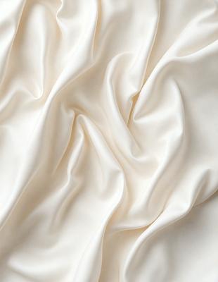 The primary subject of the image is a white sheet of fabric, which is the main object, scene, or focus of the image. The setting is a white background, which provides a clean and minimalistic environment. The visual style is a close-up of the fabric, showcasing its texture and details. The colors and mood of the image are predominantly white, giving it a clean, serene, and elegant appearance.