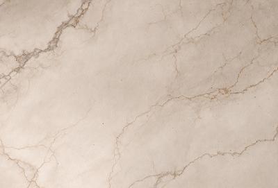 The image features a white marble wall with a pattern of brown spots. The wall appears to be a part of a building, possibly a bathroom or a kitchen. The marble surface gives the wall a luxurious and elegant appearance. The overall atmosphere of the image is clean and sophisticated.