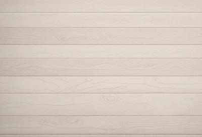 The primary subject of the image is a wooden wall with a smooth, light-colored surface. The setting is a room with a wooden floor, and the visual style is a close-up of the wooden wall. The colors and mood of the image are predominantly neutral, with a focus on the natural texture and grain of the wood.