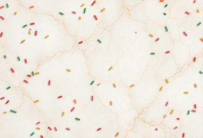 The primary subject of the image is a close-up of a marble surface with a variety of colorful candy pieces, including red, green, yellow, and orange, scattered across it. The setting is a white marble countertop, and the visual style appears to be a combination of a photo and digital art. The colors and mood of the image are vibrant and cheerful, with the candy pieces creating a playful and inviting atmosphere.