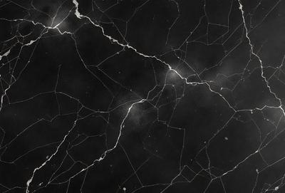 The image features a black marble surface with a pattern of white lines. The marble appears to be cracked, giving it a unique and textured appearance. The black and white color scheme creates a striking contrast, making the marble stand out as the primary subject of the image. The setting appears to be a room with a black background, which further emphasizes the marble's visual impact. The visual style of the image is a close-up, allowing the viewer to appreciate the intricate details of the marble's